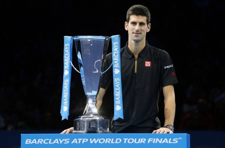 Novak Djokovic of Serbia stands behind the trophy after Roger Federer of Switzerland forfeited due to injury in the men's singles final at the ATP World Tour Finals at the O2 in London, November 16, 2014. REUTERS/Suzanne Plunkett