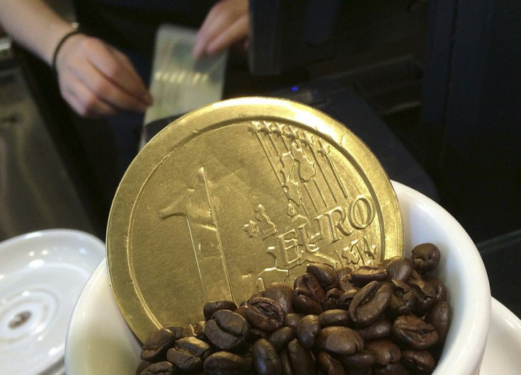 An employee uses a cash till, behind a chocolate shaped as a one Euro coin and placed for sale in a coffee cup, at a cafe in central London October 15, 2014.