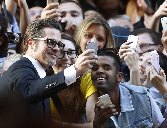 Actor Brad Pitt L takes a selfie with fans at the world premiere of his wife Angelina Jolies film quotUnbrokenquot at the State Theatre in Sydney, November 17, 2014. The war drama, based on the life of World War Two American prisoner of war Louis