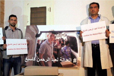 Colleagues of U.S. aid worker Abdul-Rahman Kassig carry signs during a news conference