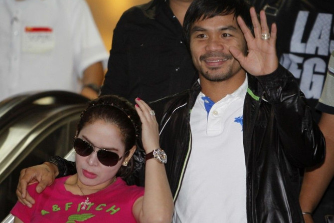 Filipino boxing icon Manny Pacquiao waves beside his wife Jinkee upon his arrival at the Ninoy Aquino International Airport in Manila December 12, 2012. Pacquiao said he felt &quot;fine&quot; on Sunday after his sensational sixth-round knockout by Mexican