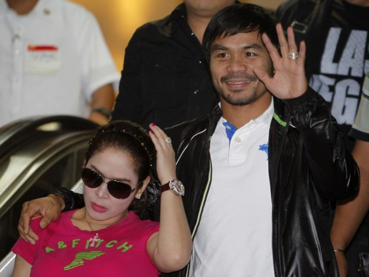 Filipino boxing icon Manny Pacquiao waves beside his wife Jinkee upon his arrival at the Ninoy Aquino International Airport in Manila December 12, 2012. Pacquiao said he felt &quot;fine&quot; on Sunday after his sensational sixth-round knockout by Mexican