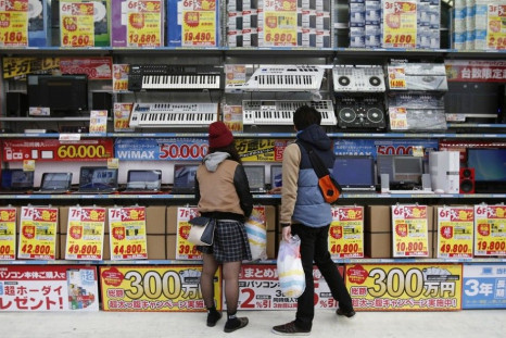 People try out laptops displayed at an electronics retail store in Tokyo November, 16, 2014. Japan's economy unexpectedly shrank an annualised 1.6 percent in July-September after a severe contraction in the previous quarter, likely solidifying the view th