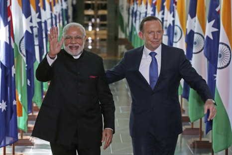 India's Prime Minister Narendra Modi waves as he walks with Australia's Prime Minister Tony Abbott