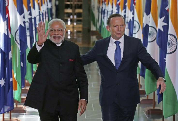 India's Prime Minister Narendra Modi waves as he walks with Australia's Prime Minister Tony Abbott