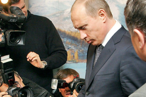 Russian President Vladimir Putin holds a gold bar while visiting an exhibition at Russia's Far Eastern gold mining center of Magadan November 22, 2005. 