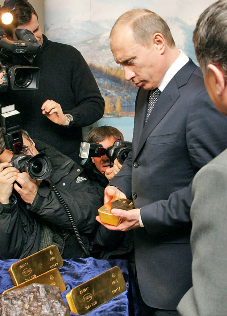 Russian President Vladimir Putin holds a gold bar while visiting an exhibition at Russia's Far Eastern gold mining center of Magadan November 22, 2005. 