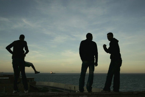 Homeless boys look out at the Strait of Gibraltar near the port in Tangier October 10, 2009. More than 10,000 homeless minors live on the streets of Morocco according to the Al Jaima association, an association that works with street kids. Most of them ar
