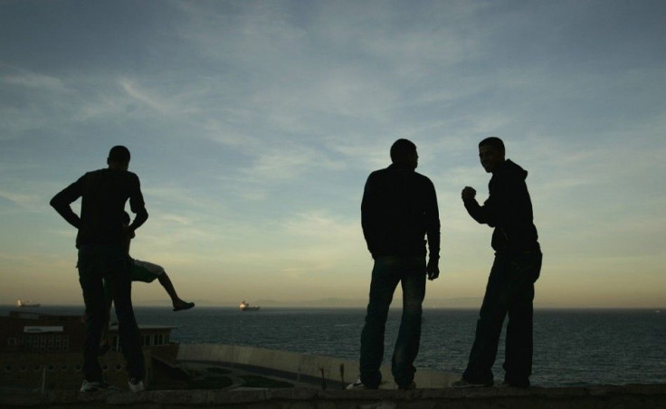 Homeless boys look out at the Strait of Gibraltar near the port in Tangier October 10, 2009. More than 10,000 homeless minors live on the streets of Morocco according to the Al Jaima association, an association that works with street kids. Most of them ar