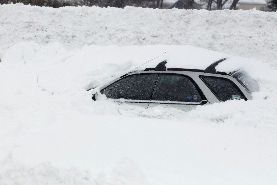 A vehicle is shown submerged in snow sits on interstate I-190 in West Seneca, New York November 19, 2014. An autumn blizzard dumped a years worth of snow on western New York state where five people died and residents, some stranded overnight in cars, bra