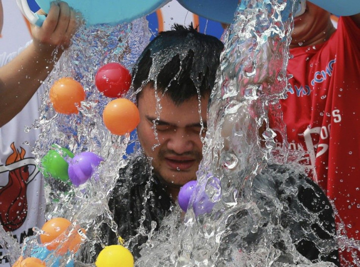Men dump buckets of ice water and plastic balls onto former NBA player Yao Ming as Yao takes part in the ALS ice bucket challenge in Beijing August 23, 2014. The Ice Bucket Challenge is aimed at raising awareness of - and money to fight - Amyotrophic Late