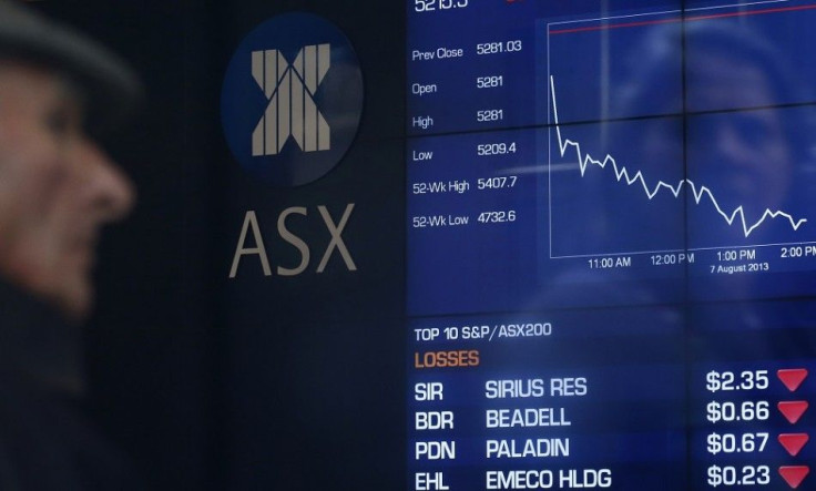 A man looks the board of the Australian Securities Exchange in central Sydney August 7, 2013. Australian shares skidded 1.3 percent on Wednesday, its biggest fall in five weeks, hit by sharp falls in miners and financials as regional markets tracked a sof