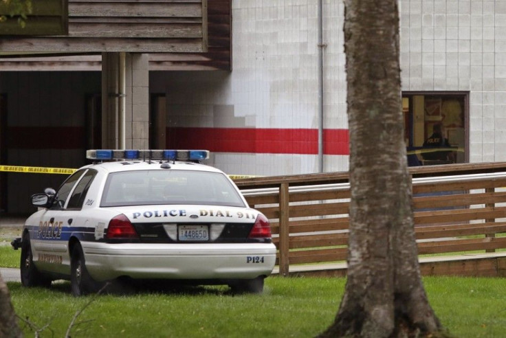 Police are seen through a window (R) as they investigate a shooting at Marysville-Pilchuck High School in Marysville, Washington October 24, 2014. A student fatally shot one classmate and wounded four others when he opened fire in the cafeteria of the sch