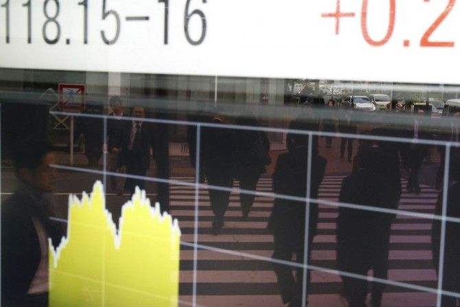 People are reflected on an electronic board showing the Japanese yen's exchange rate against the U.S. dollar outside a brokerage in Tokyo November 20, 2014. Asian stocks mostly fell on Thursday as fresh data signalling a further loss of momentum in China'