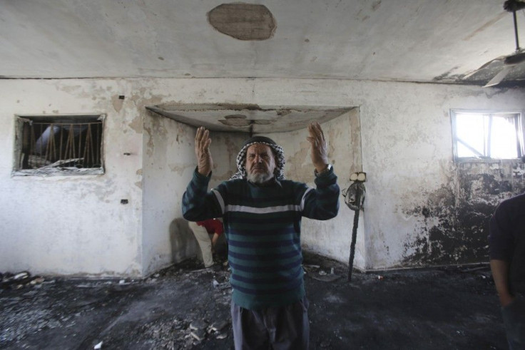 A Palestinian man prays at a damaged mosque after it was set ablaze, in the West Bank village of Mghayr near Ramallah November 12, 2014.