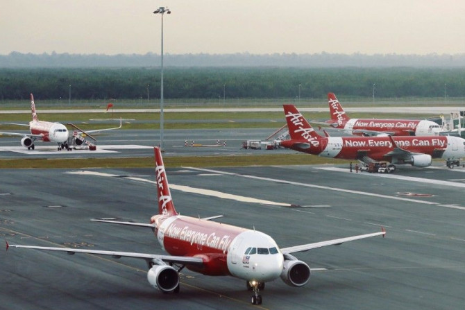 AirAsia planes are seen on the runway at Kuala Lumpur International Airport August 19, 2014. AirAsia Bhd, Asia's largest budget airline by passengers, said second-quarter net profit rose 529 percent due to foreign exchange gains, the deferment of tax