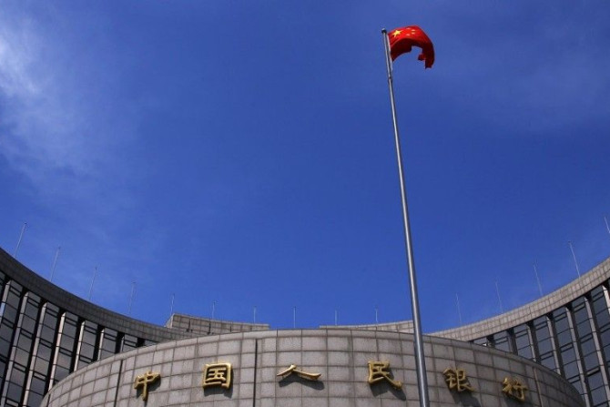 A Chinese national flag flutters in front of the headquarters of the People's Bank of China, China's central bank, in central Beijing, May 16, 2014. The bank is injecting a combined 500 billion yuan ($81.35 billion) of liquidity into the country's top ban