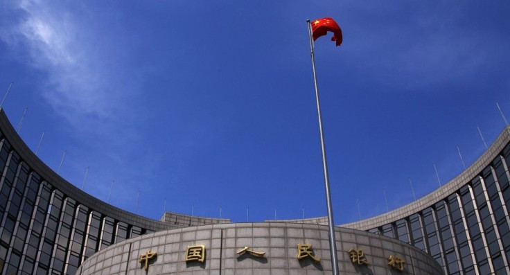 A Chinese national flag flutters in front of the headquarters of the People's Bank of China, China's central bank, in central Beijing, May 16, 2014. The bank is injecting a combined 500 billion yuan ($81.35 billion) of liquidity into the country's top ban