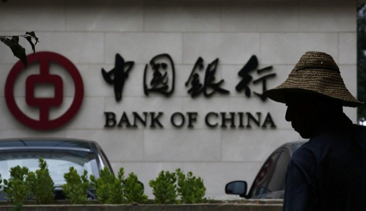 A man is silhouetted in front of a Bank of China's logo at its branch office in Beijing July 14, 2014. China's central bank is looking into allegations by a state broadcaster that Bank of China, the country's fourth largest lender, has been laundering mon