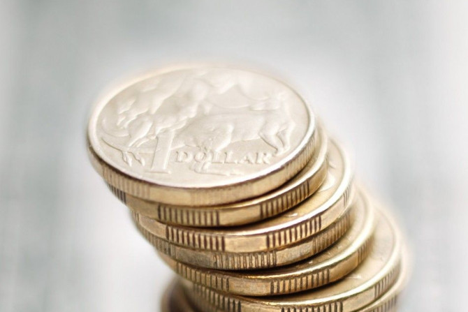 A stack of Australian one dollar coins stand on a U.S. one dollar note in this photo illustration taken in Sydney July 27, 2011. Australian consumer prices rose by more than expected last quarter while underlying inflation proved alarmingly high, reviving