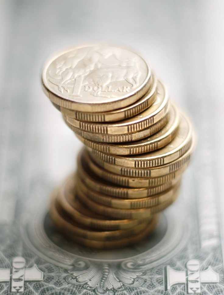 A stack of Australian one dollar coins stand on a U.S. one dollar note in this photo illustration taken in Sydney July 27, 2011. Australian consumer prices rose by more than expected last quarter while underlying inflation proved alarmingly high, reviving