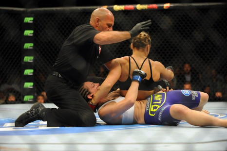 Jul 5, 2014; Las Vegas, NV, USA; The referee stops the fight during the first round after Alexis Davis (blue gloves) gets knocked out by Ronda Rousey (red gloves) during a bantamweight fight at Mandalay Bay Events Center.