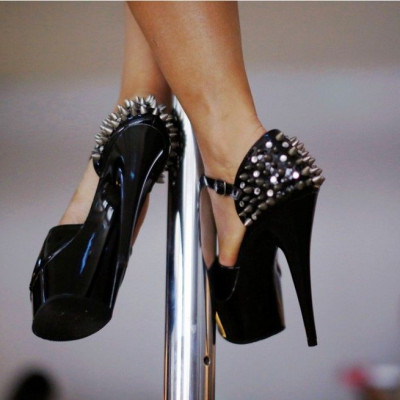 A woman wears spiked stilettos as she practises a pole dancing move during an International Women&#039;s Day event