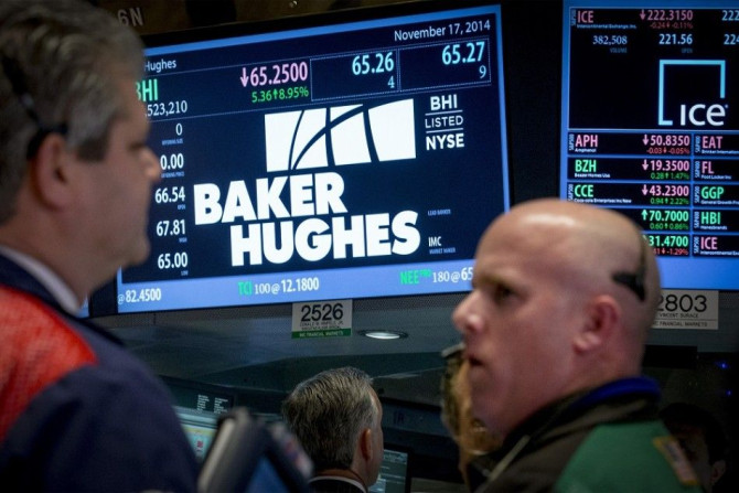 Traders work by the post that trades Baker Hughes on the floor of the New York Stock Exchange November 17, 2014. Halliburton Co said on Monday it will buy Baker Hughes Inc for about $35 billion in cash and stock, creating an oilfield services behemoth to 