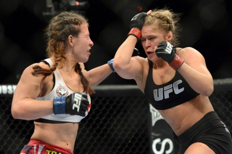 Dec 28, 2013; Las Vegas, NV, USA; Ronda Rousey (red gloves) and Miesha Tate (blue gloves) fight during their UFC women's bantamweight championship bout at the MGM Grand Garden Arena.