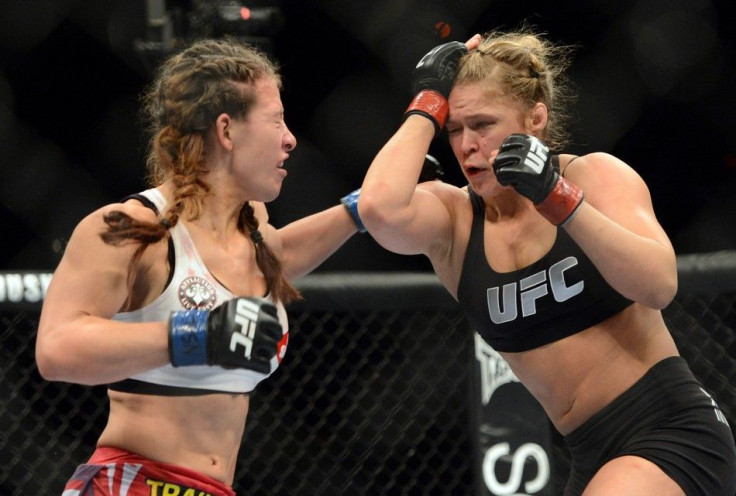 Dec 28, 2013; Las Vegas, NV, USA; Ronda Rousey (red gloves) and Miesha Tate (blue gloves) fight during their UFC women's bantamweight championship bout at the MGM Grand Garden Arena.