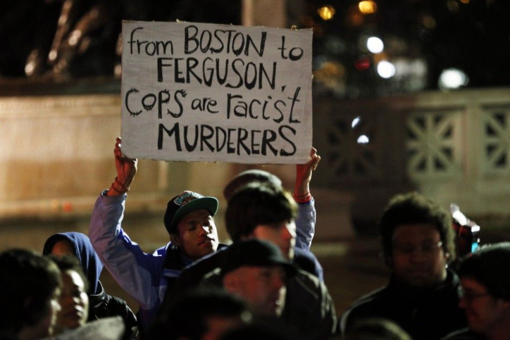 A man holds a sign reading &quot;From Boston to Ferguson, cops are racist murderers&quot;