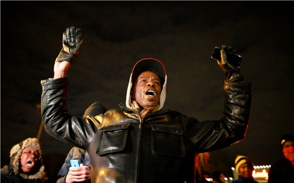 A protester holds his hands in the air outside the Ferguson Police Department in Ferguson, Missouri