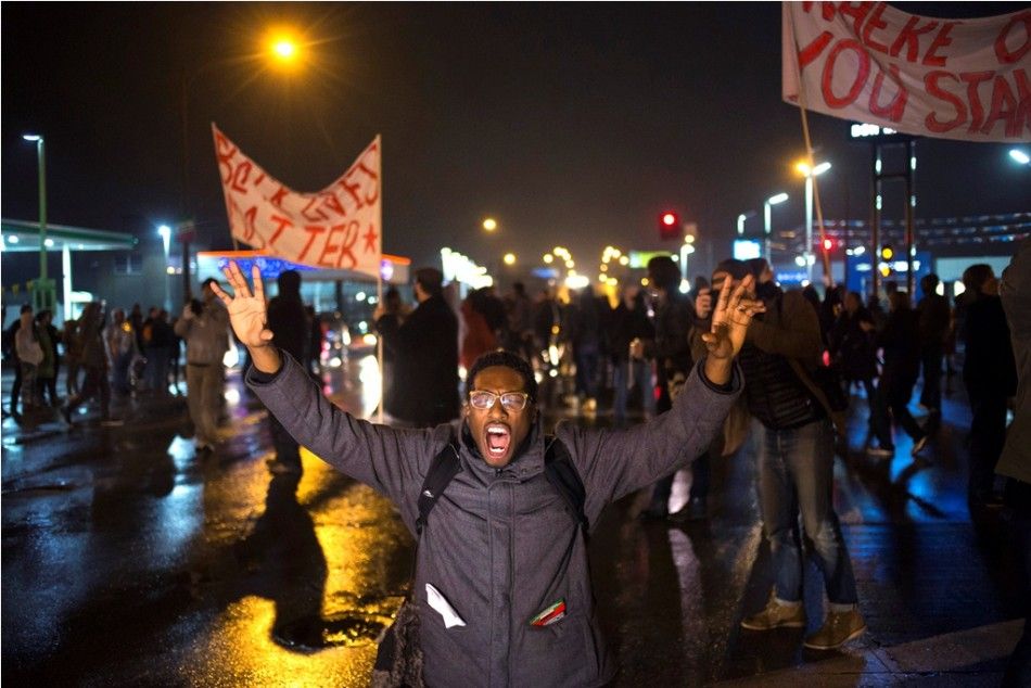 A protester, demanding the criminal indictment of a white police officer who shot dead an unarmed black teenager in August, shouts slogans while stopping traffic