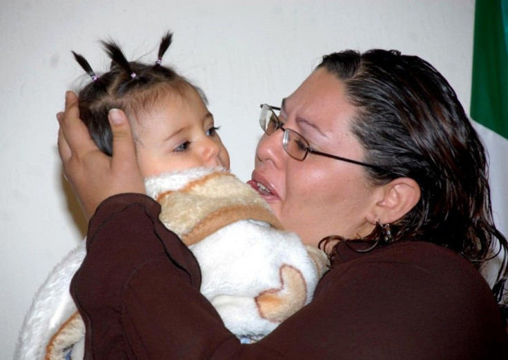 Vanessa Castillo holds her one-year-old daughter during a news conference in Mexico City November 5, 2009.
