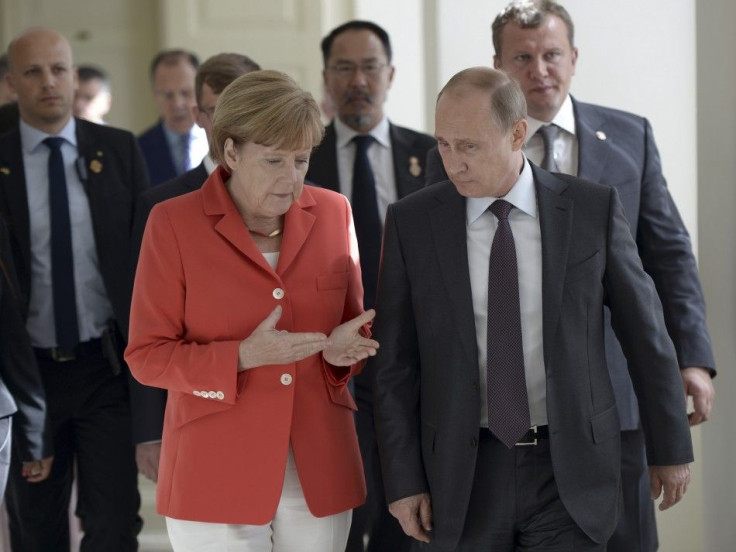 Russian President Vladimir Putin (R) and German Chancellor Angela Merkel walk during a meeting in Rio de Janeiro July 13, 2014. 