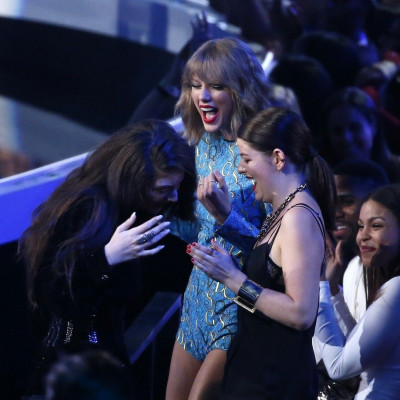 Lorde (L) reacts with singer Taylor Swift and an unidentified guest (R) after she won the award for best rock video for &quot;Royals&quot; during the 2014 MTV Video Music Awards in Inglewood, California August 24, 2014.