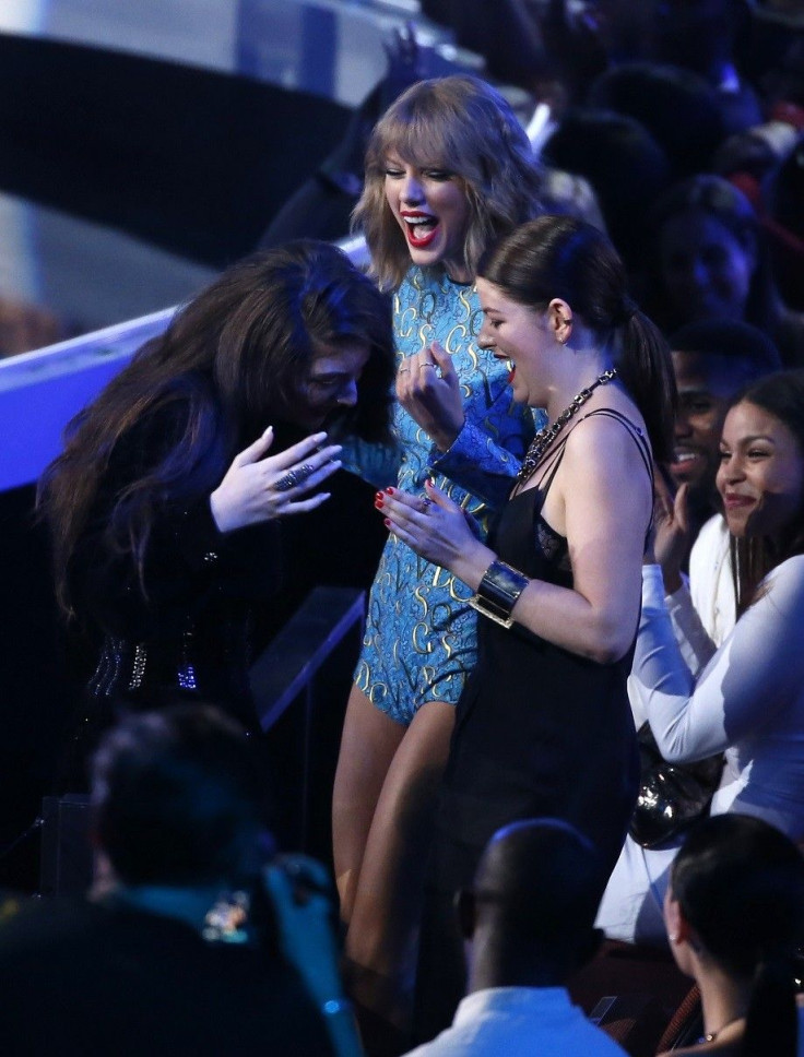 Lorde (L) reacts with singer Taylor Swift and an unidentified guest (R) after she won the award for best rock video for &quot;Royals&quot; during the 2014 MTV Video Music Awards in Inglewood, California August 24, 2014.