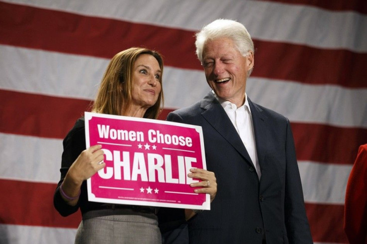 Former President Bill Clinton laughs with Carol Crist, wife of former Florida Governor and Democratic gubernatorial candidate Charlie Crist, at the final stop of a state-wide bus campaign tour in Orlando, Florida, November 3, 2014. Florida Republican Gove