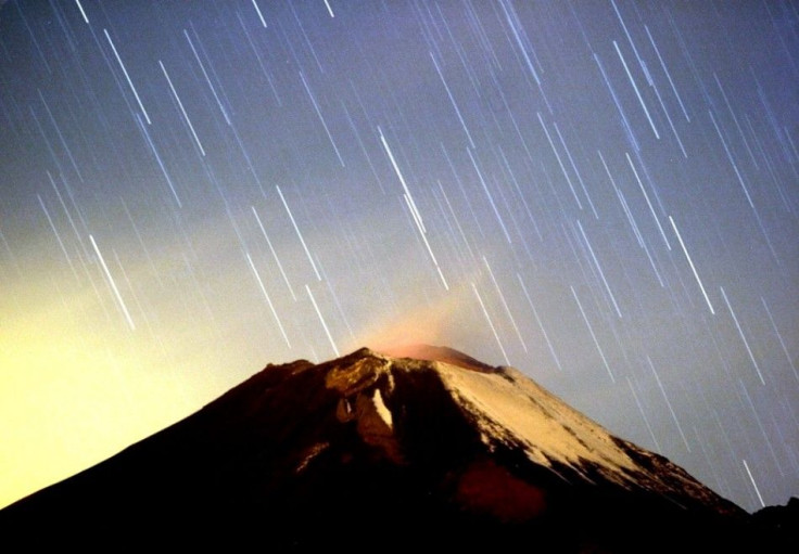 A meteor shower lights up the sky over the Mexican volcano Popocatepetl near the village San Nicolas de los Ranchos in Mexican state of Puebla in the early hours of December 14, 2004. The shower, named Geminid because it appears to originate from the cons