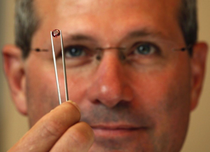 Alan Davies, chief executive of Rio Tinto&#039;s diamonds and minerals division, poses with a rare pink diamond in Hong Kong September 6, 2013. The Argyle Pink Diamond Tender, showcasing the finest coloured diamonds from Rio Tinto Ltd&#039;s mine in north
