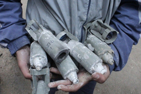 A boy holds unexploded cluster bombs after jet shelling by forces loyal to Syria&#039;s President Bashar al-Assad in the al-Meyasar district of Aleppo February 21, 2013.