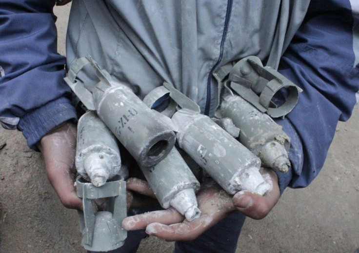 A boy holds unexploded cluster bombs after jet shelling by forces loyal to Syria&#039;s President Bashar al-Assad in the al-Meyasar district of Aleppo February 21, 2013.