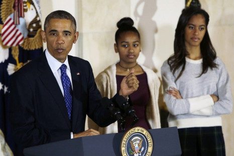 U.S. President Barack Obama delivers remarks, along with daughters Sasha and Malia (R),before pardoning the National Thanksgiving Turkey &quot;Cheese&quot; (not pictured) at the White House in Washington November 26, 2014.