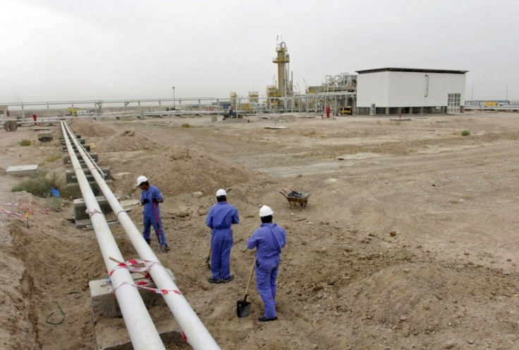 People work at the West Qurna oilfield in southern Basra October 13, 2014. Oil prices are hovering just above $90 per barrel, a level last seen in June 2012, putting a strong spotlight on OPEC producing countries. They face calls to cut output at, or befo