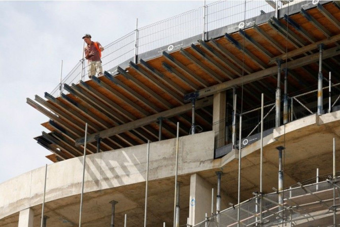 A construction worker looks over the top of Queensland Terrace