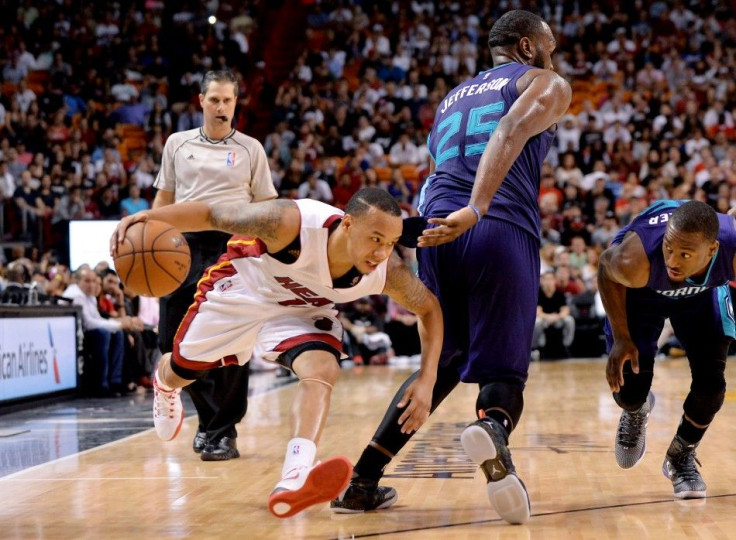 Miami Heat guard Shabazz Napier (13) drives to the basket as Charlotte Hornets center Al Jefferson (25) defends during the second half at American Airlines Arena. 94-93.