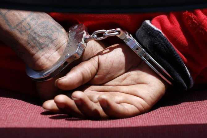 The handcuffs of a suspected member of the Broadway Gangster Crips street gang is seen while being interviewed by a law enforcement officer after he was arrested in Los Angeles, California June 17, 2014. REUTERS/Jonathan Alcorn