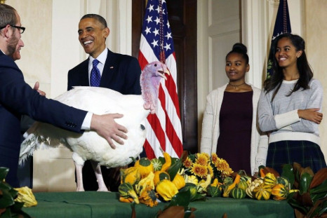 U.S. President Barack Obama and his daughters, Sasha (C), and Malia (R), participate in the annual turkey pardoning ceremony marking the 67th presentation of the National Thanksgiving Turkey while in the White House in Washington, November 26, 2014.