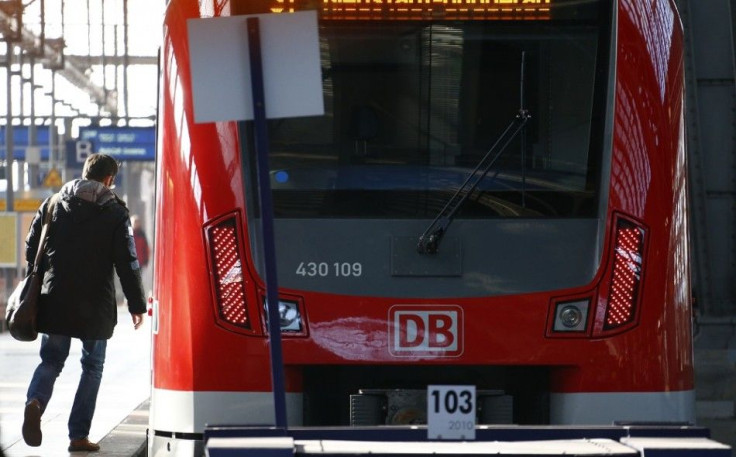 A man walks to a train of Deutsche Bahn railway operator at the main train station in Frankfurt November 21, 2014.