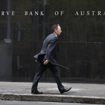 A businessman walks past the Reserve Bank of Australia in Sydney February 4, 2014. Australia's central bank kept its main cash rate at a record low of 2.5 percent on Tuesday as widely expected but surprised some by saying further cuts were not in the card
